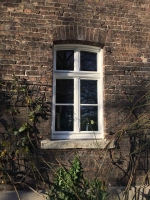 Fenster mit Zierelementen und Segmentbogen in historischer Fassade